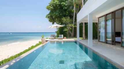 Fototapeta premium A pool with a white umbrella and a beach in the background