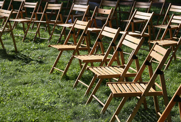 Row of folding chairs on the grass in the park