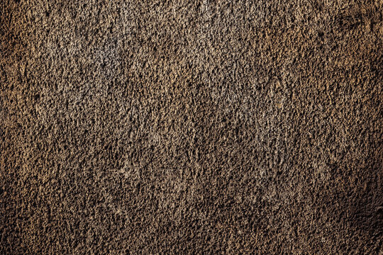 Braune Wand mit grobem Putz und Schmutz