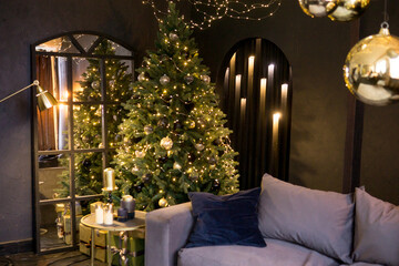 Christmas interior with a beautiful Christmas tree, sofa, light bulbs and dark background.