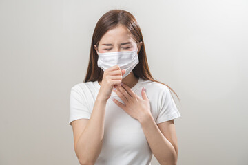 Unhealthy sickness, unwell asian young woman wearing mask coughing, have sore throat, suffering symptom cough feeling bad and healthcare of air pollution and dust, PM2.5 isolated white background.