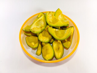 Thick Slices of Avocado Stacked Together on a Plate with Yellow Accent Against a White Background: Fresh and Creamy Avocado Presentation in a Bright, Minimalist Setting