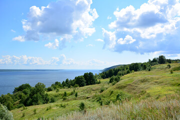 Fototapeta premium a hill with a lake and the sky with clouds wallpaper 