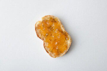 Toast with plum jam on a white table