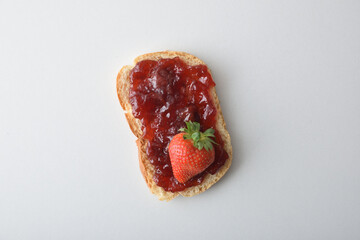 Toast with strawberry jam on a white table