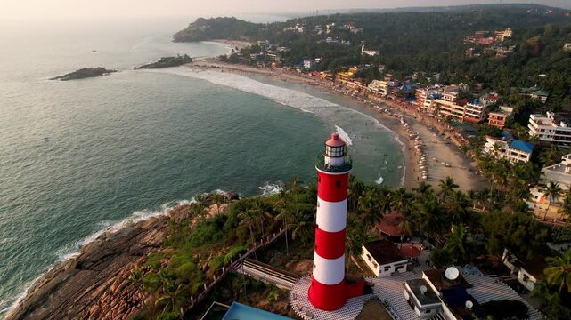 Lighthouse on the sea coastline at sunset, aerial view. Kovalam Beach whith Lighthouse in India, Kerala