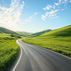 Naklejka premium A serene winding road through lush green hills under a bright blue sky with fluffy clouds, perfect for nature lovers.