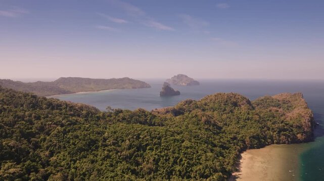 Establishing aerial view of tropical paradise exotic island surrounded by crystal blue sea and sail boats. Travel video of Bukal island El Nido Philippines, untouched nature on sunny summer day