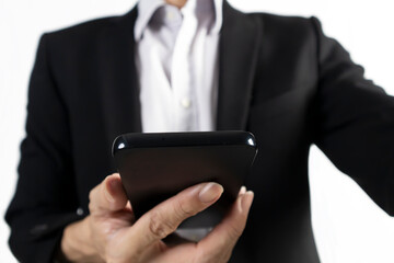 Businessman in black suit standing holding mobile phone to view work data and check work
