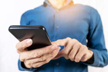 Businessman using mobile phone to read messages and touch the mobile screen to work through mobile phone.