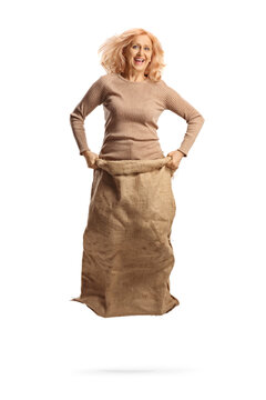Full length portrait of a middle aged woman jumping in a sack and playing gunny race