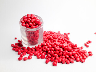 Rubine red masterbatch granules on white background.Color pigment carrier polymer in plastics industry