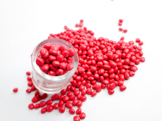 Rubine red masterbatch granules on white background.Color pigment carrier polymer in plastics...
