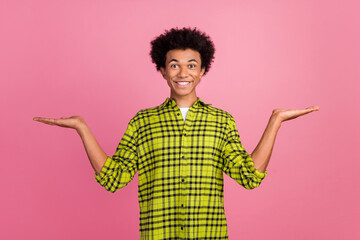 Portrait of nice young man hold empty space scales wear shirt isolated on pink color background