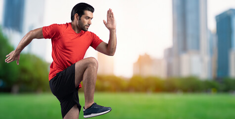 Athletic and sporty man running posture at outdoor green city park exercise session for fit physique and healthy outdoor sport lifestyle. Gaiety green park exercise workout training.