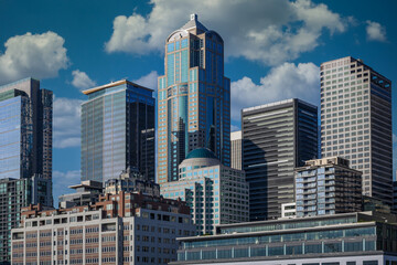 Fototapeta premium 2024-08-15 SEATTLE SKYLINE WITH SEVERAL OFFICE TOWERS AND A SKY WITH WHITE PUFFY CLOUDS 