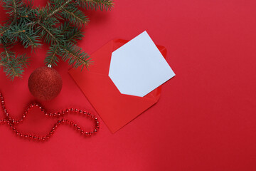 A pine branch, a red Christmas ornament, and a string of red beads add holiday cheer to the composition..