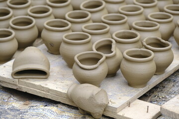 Skilled potter shaping the clay into pot on spinning wheel, Indian earthenware.