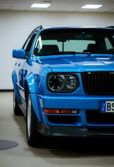 Naklejka premium Pink flower cA close-up view of the side of a sleek, modern sports car. The car has a matte gray finish and large black alloy wheels with a distinctive spoke design. The carlose up on black background