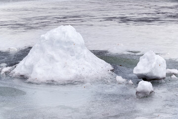 Large snowdrift on snow-covered lake ice on a frosty winter day.