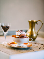 Schoko-Eisbecher mit Vanille, Sahne und Schokolade elegant angerichtet in einer Kaffeetasse