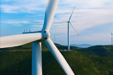 Closeup wind turbine produce energy in the green hills, modern power plant, alternative energy...