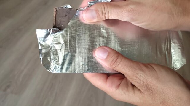 Unpacking the foil chocolate. expired chocolate. 