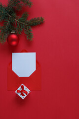 A pine branch, a red Christmas ornament and red gift box.