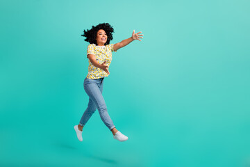 Full size photo of nice young woman jump run empty space wear t-shirt isolated on teal color background