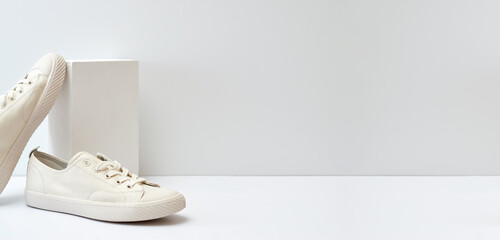 Pair of stylish sneakers on white background with geometric podium
