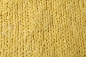 Texture of yellow knitted fabric as background, top view