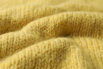 Texture of yellow knitted fabric as background, closeup