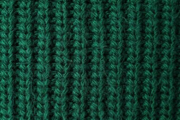 Texture of green knitted fabric as background, top view