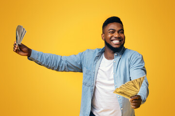 Big Win. Overjoyed African American Man Holding A Lot Of Money In Both Hands On Yellow Background,...