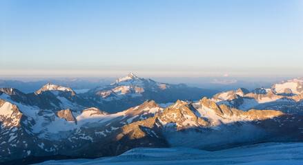 mountain peaks in morning dawn light, panoramic natural landscape