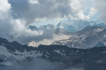 beautiful mountainous landscape, peaks and glaciers among clouds