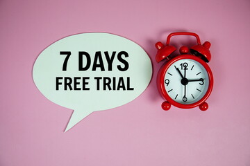 7 Days Free trial text on speech bluble with alarm clock top view on pink background