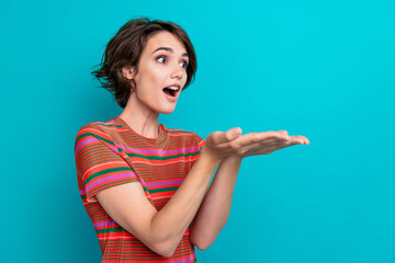 Photo of speechless nice woman dressed striped t-shirt astonished staring at empty space on palms...