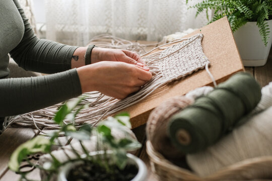 Woman weaving macrame in her cozy home workshop