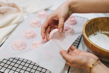 Homemade pink marshmallows on baking paper background on the kitchen