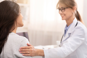 Obraz premium Cheerful Doctor Lady Comforting Her Patient During Medical Checkup In Clinic Office. Selective Focus
