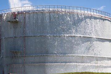 A large storage tank with gasoline, oil, fuel oil, flammable substances is extinguished with fire...