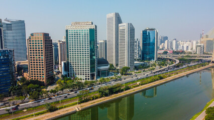 Fototapeta premium Vista aérea de prédios comerciais à beira da Marginal Pinheiros, com a paisagem urbana de São Paulo ao fundo