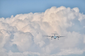 Turbo Prop airplane flying in fluffy clouds