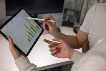 Businesspeople discussing graph on digital tablet. People working together in the meeting room office.