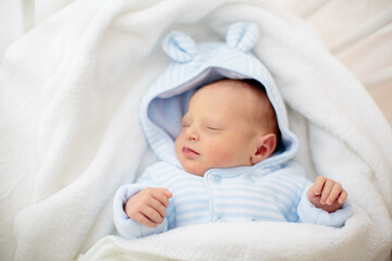 Newborn baby boy in hospital cot