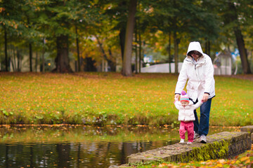 Obraz premium Child in fall park. Kid with autumn leaves.