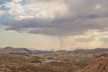 Rain in Distance Water Falling Clouds Over Desert Landscape