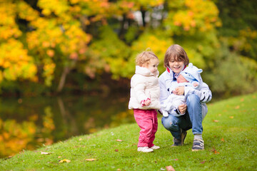 Fototapeta premium Child in fall park. Kid with autumn leaves.