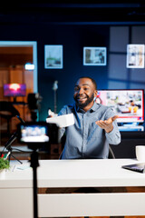 African american internet show host being sponsored by partnering brand to do unboxing video on streaming platform. BIPOC man does influencer marketing, presenting viewers product ad